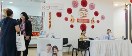 Staff at the KPJ Sabah Specialist Hospital information counter during a Chinese New Year celebration.